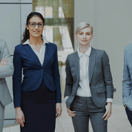 Four people standing wearing professional suits