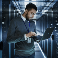 A man using his computer in the server room