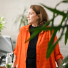 Woman in orange shirt working.