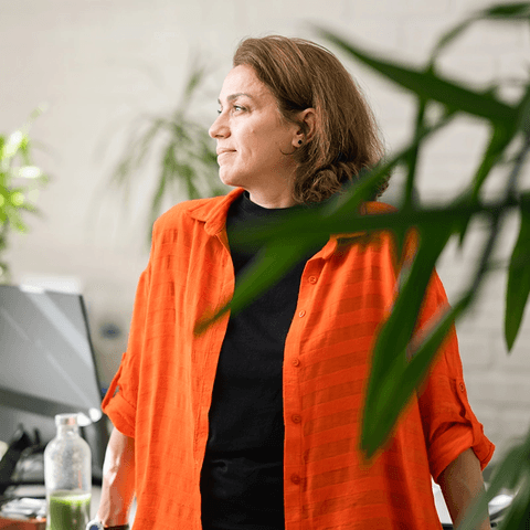 Woman in orange shirt working.