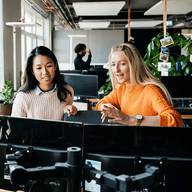 Two women collaborating at computers.