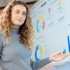 A woman and a screen with data charts