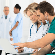 Two doctors examining over a laptop