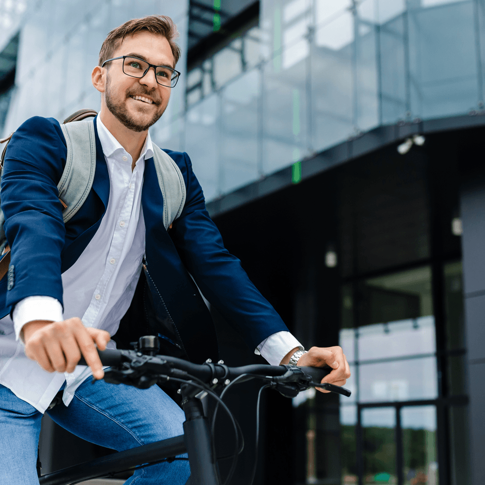 A smiling riding his bike