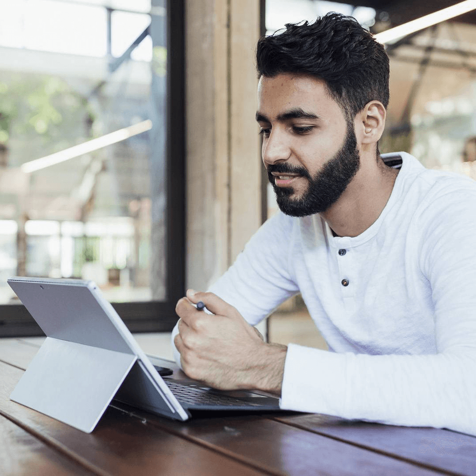 Person sitting at table using tablet