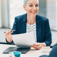 A smiling woman with paper on her hand