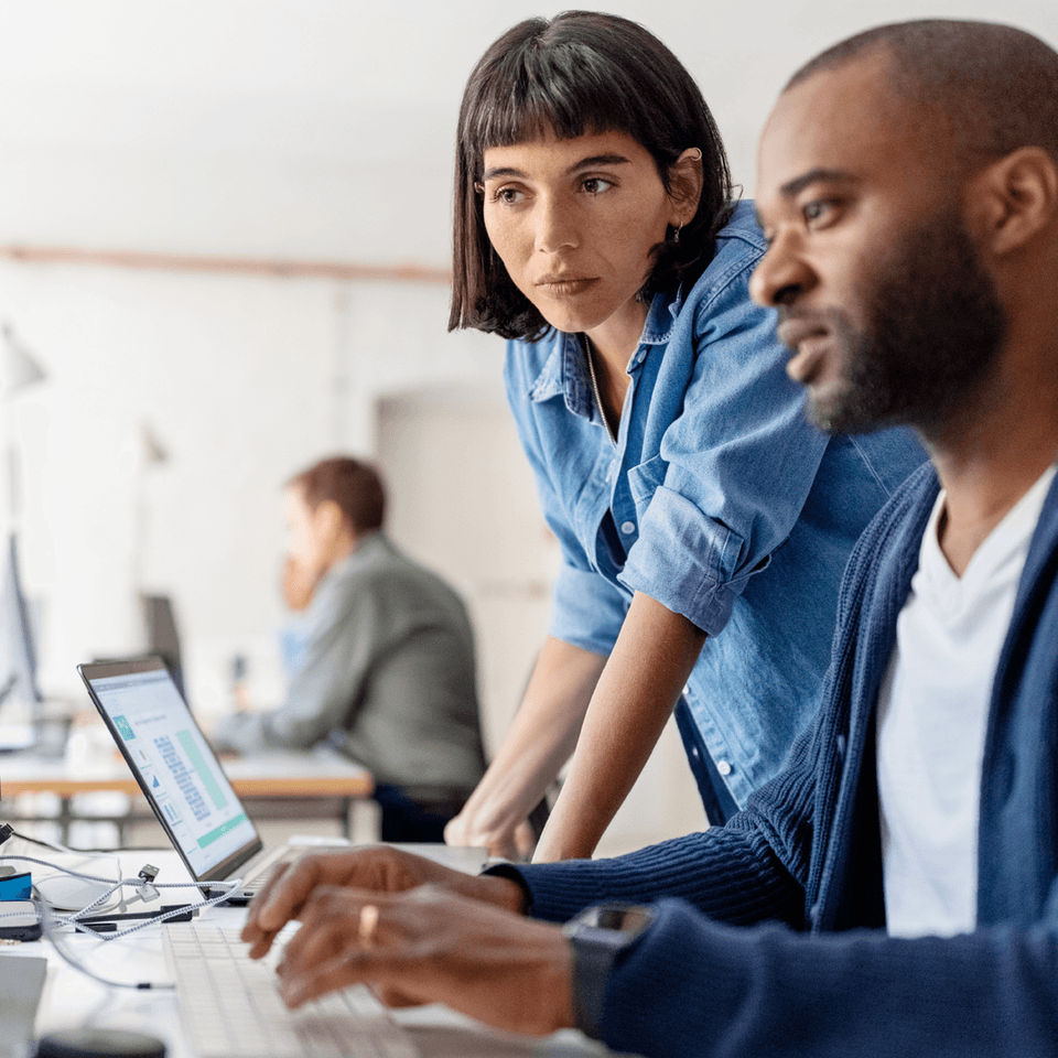 A man and a woman looking at laptop at work