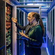 two people working together in a server room